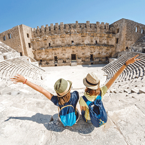 Tourists celebrate in ancient amphitheater.