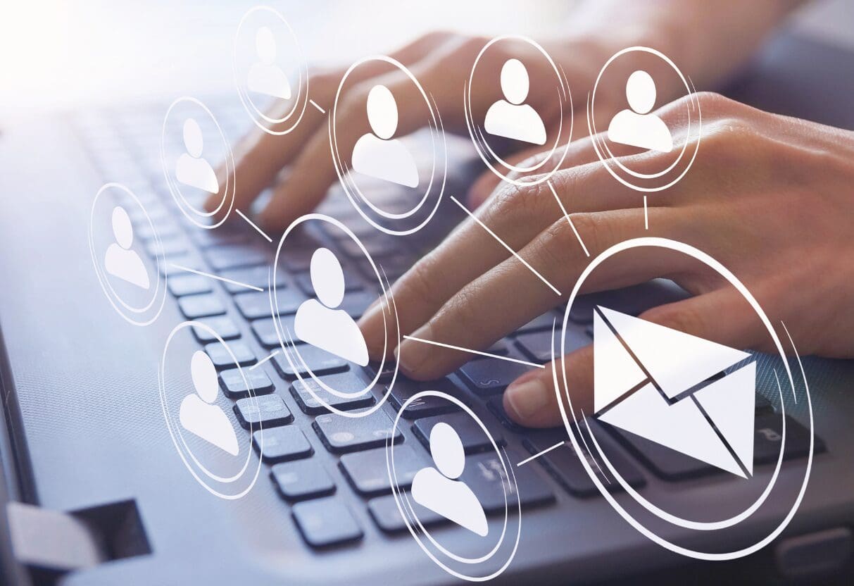 Hands typing on a laptop with floating email and subscriber icons, illustrating building a high-quality email list to boost direct bookings and ROI for tourism and hospitality businesses through targeted newsletters and segmentation.